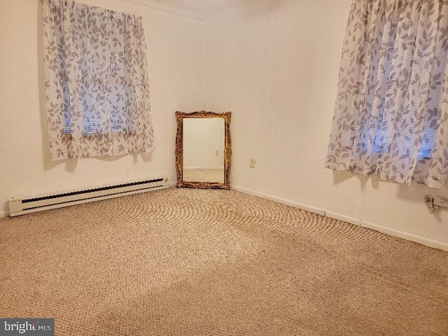 carpeted spare room with ornamental molding and a baseboard heating unit