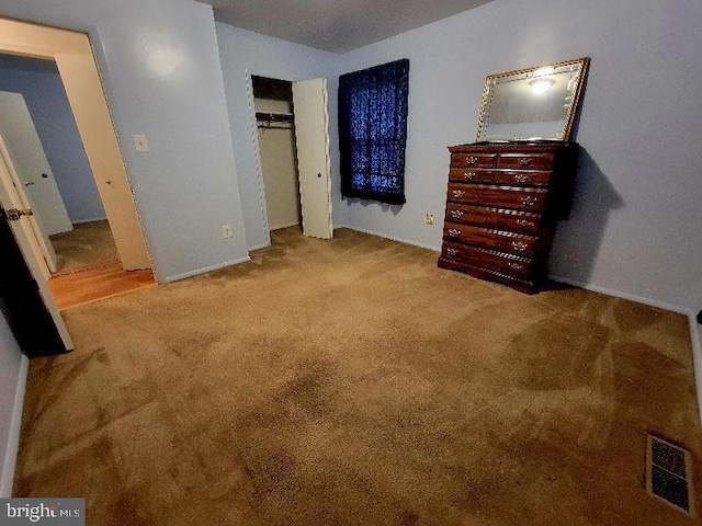 unfurnished bedroom featuring light colored carpet and a closet