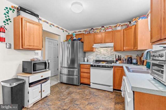 1025 Harmony Hl, Lebanon, PA 17046 - kitchen featuring stainless steel appliances, light countertops, stone finish floor, under cabinet range hood, and backsplash