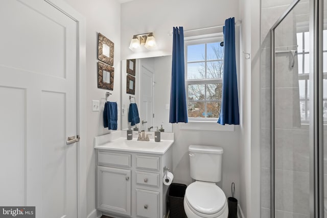 bathroom with a shower with door, toilet, and vanity