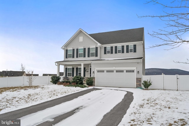 view of front facade with a garage, a mountain view, and covered porch