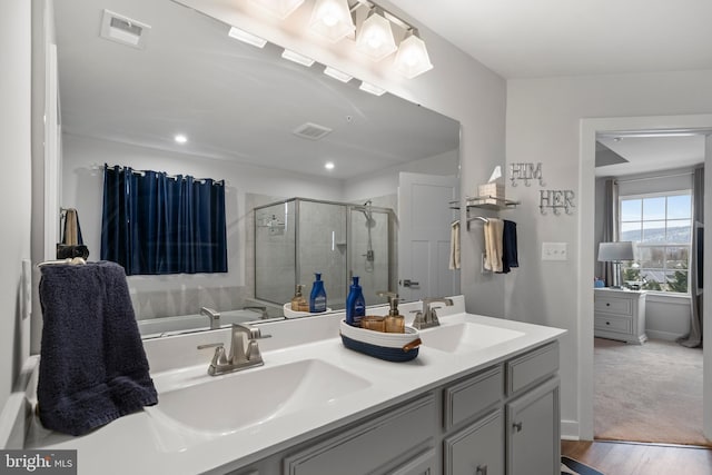 bathroom featuring walk in shower, vanity, and wood-type flooring