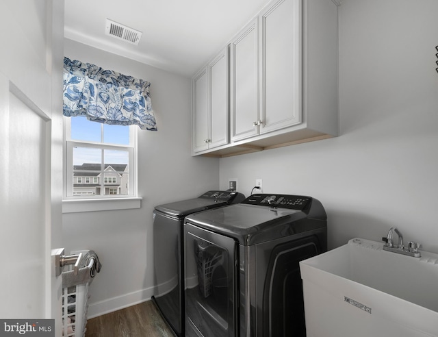 washroom with independent washer and dryer, dark hardwood / wood-style floors, sink, and cabinets