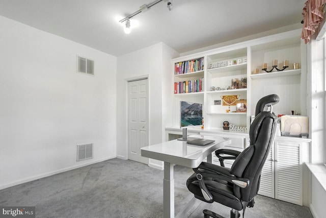 home office with rail lighting and light carpet