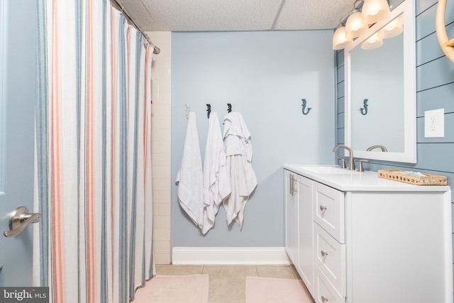 bathroom featuring a drop ceiling, vanity, curtained shower, and tile patterned floors