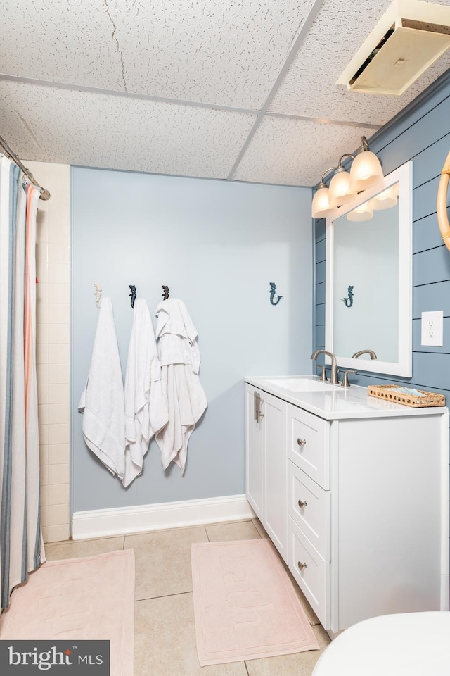 bathroom with vanity, a drop ceiling, tile patterned floors, and curtained shower