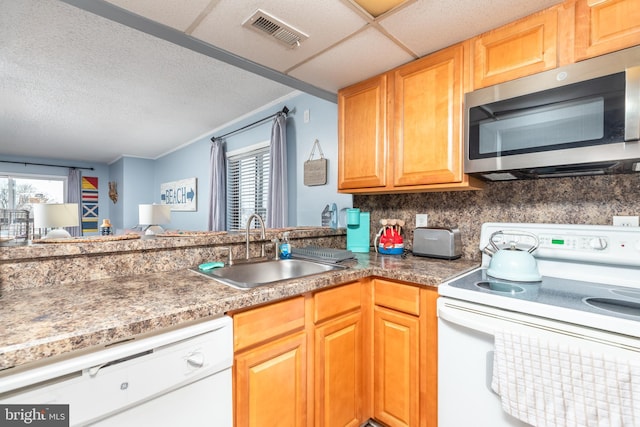 kitchen featuring backsplash, white appliances, sink, and a wealth of natural light