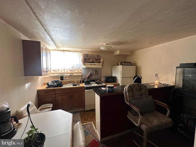 office space with a textured ceiling, wood-type flooring, and sink