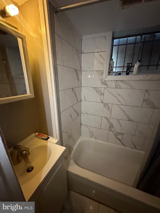 bathroom with vanity and tiled shower / bath