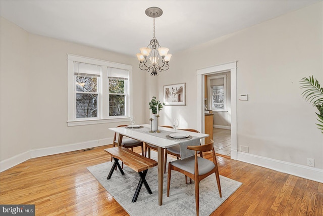 dining area featuring light hardwood / wood-style flooring and a notable chandelier