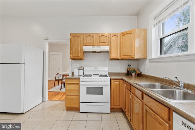 kitchen featuring light tile patterned floors, white appliances, and sink