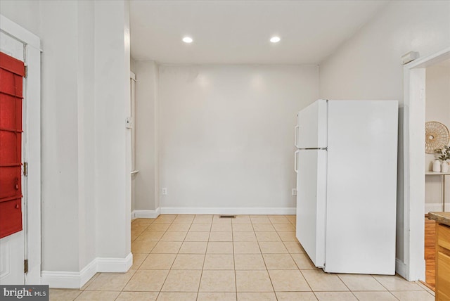 kitchen with white fridge and light tile patterned flooring