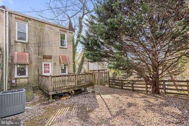 back of house with a deck and central air condition unit