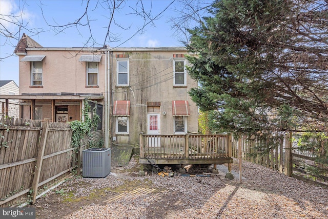 rear view of property with central AC and a wooden deck