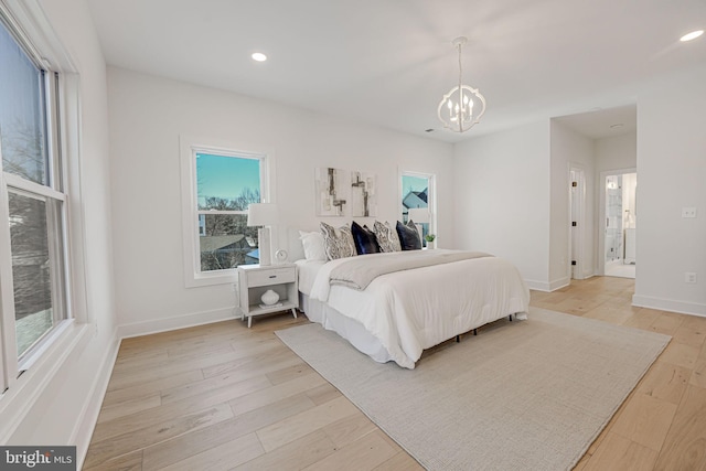 bedroom with a chandelier and light hardwood / wood-style floors