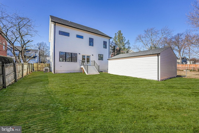 rear view of property with a lawn and central air condition unit