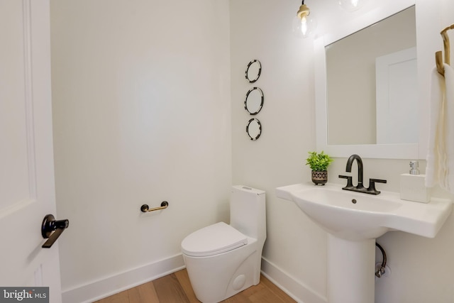 bathroom with toilet and hardwood / wood-style floors