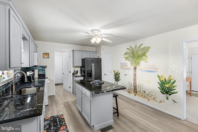 kitchen featuring dark stone counters, gray cabinetry, a kitchen island, and stainless steel appliances