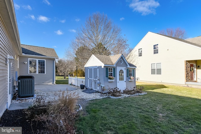 exterior space with a lawn, an outdoor structure, and central air condition unit