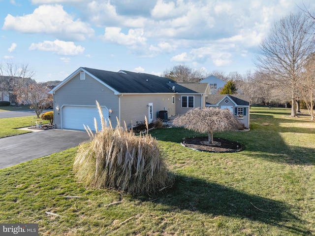 view of home's exterior featuring central air condition unit, a lawn, and a garage