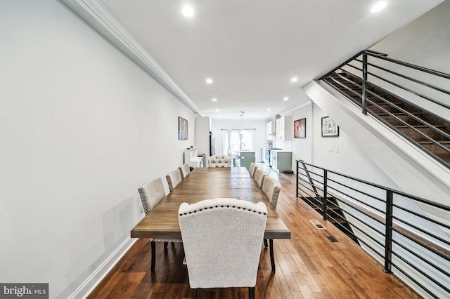 dining area with hardwood / wood-style floors and ornamental molding