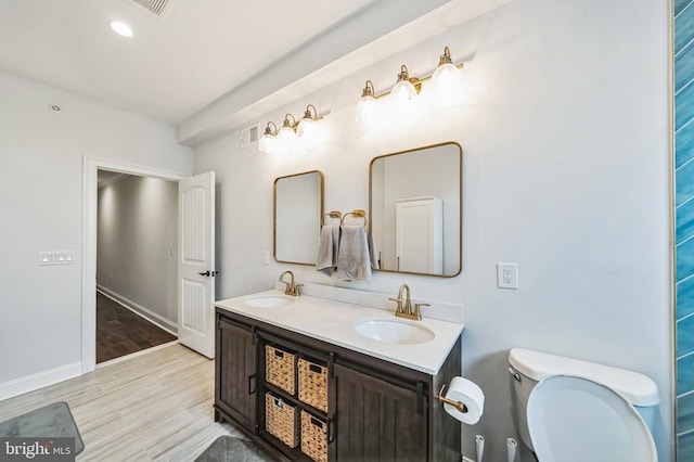 bathroom with hardwood / wood-style floors, vanity, and toilet