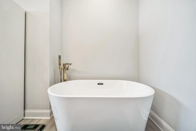 bathroom with a bathing tub and hardwood / wood-style floors