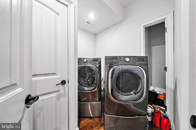 laundry area featuring washing machine and clothes dryer and wood-type flooring