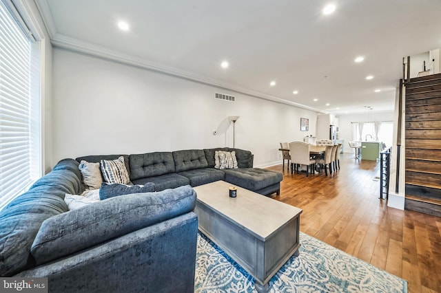 living room with wood-type flooring and crown molding