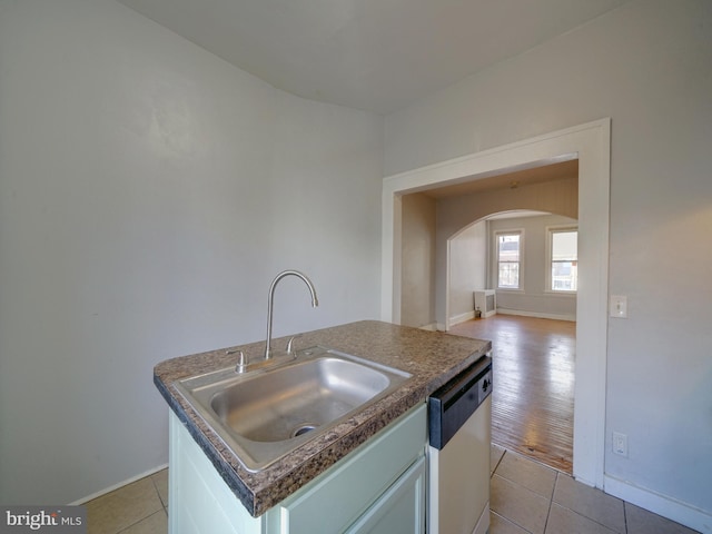 kitchen with dishwasher, a center island with sink, light tile patterned flooring, and sink