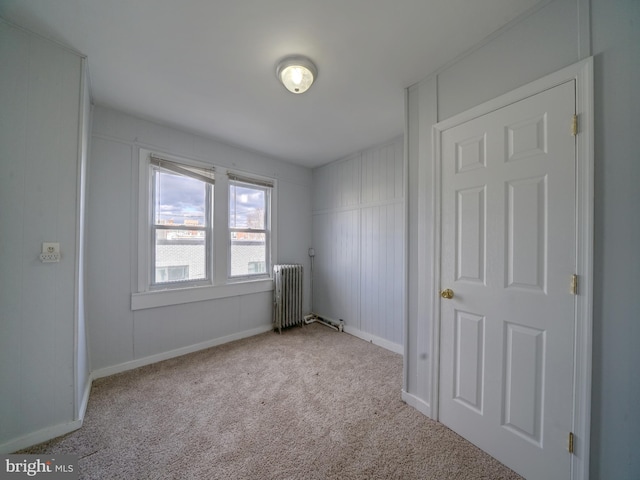 carpeted spare room featuring radiator heating unit