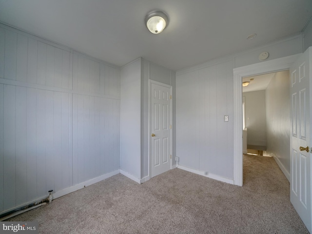 unfurnished bedroom with crown molding and light carpet