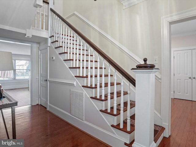 stairs with hardwood / wood-style flooring and crown molding