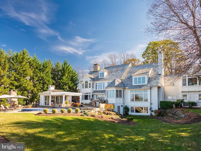 back of house with a yard and a swimming pool