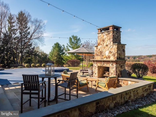 view of patio / terrace featuring an outdoor stone fireplace