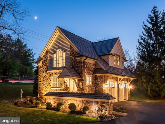 view of front of house featuring a garage and a lawn