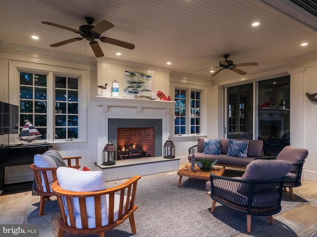 living room with ceiling fan, wood ceiling, and a tiled fireplace