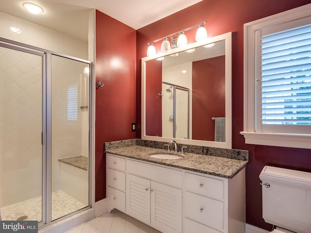 bathroom with tile patterned flooring, a shower with door, vanity, and toilet