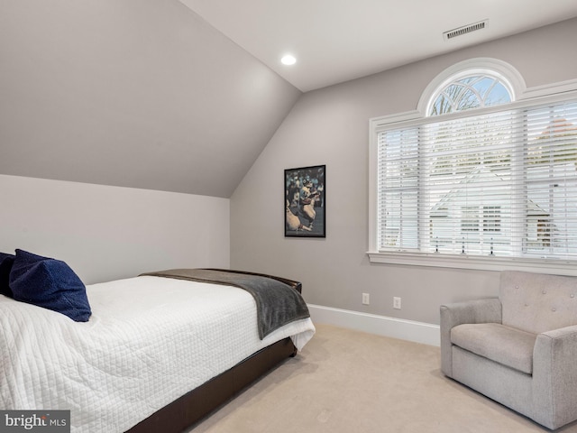 bedroom with light carpet and lofted ceiling