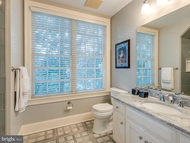 bathroom featuring plenty of natural light, toilet, and vanity