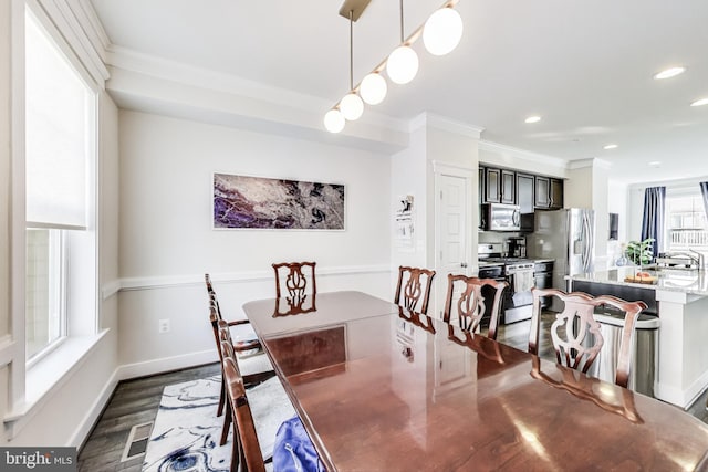 dining room with a healthy amount of sunlight, dark wood-type flooring, and ornamental molding