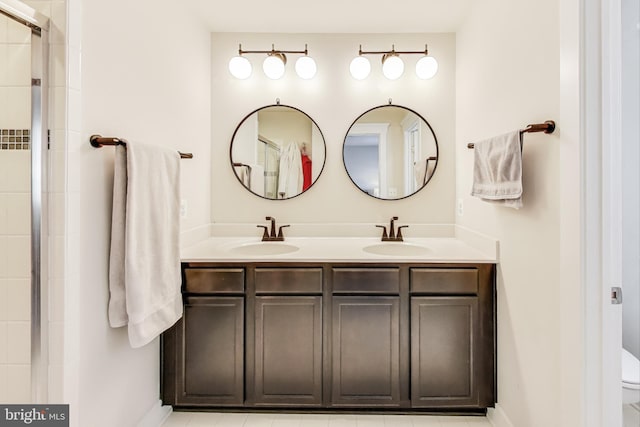 bathroom featuring toilet, a shower with shower door, and vanity