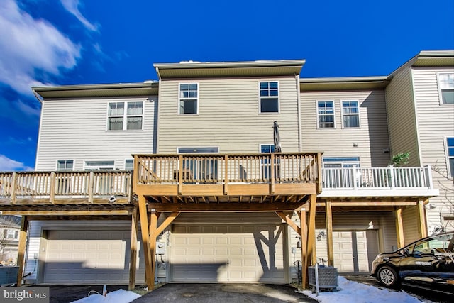 back of house featuring a deck, a balcony, and a garage