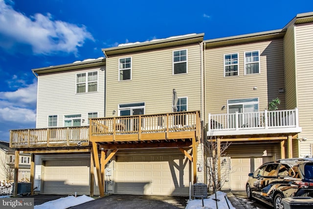 back of property with central AC and a balcony