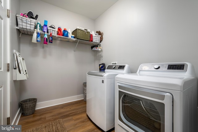 clothes washing area with dark hardwood / wood-style flooring and washer and clothes dryer