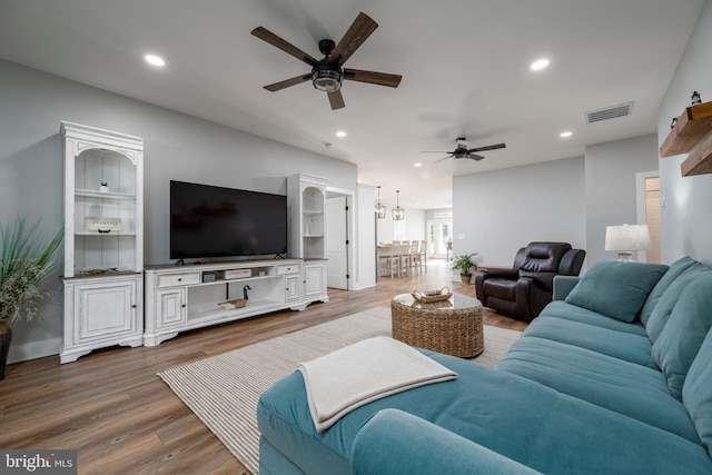 living room featuring hardwood / wood-style flooring and ceiling fan