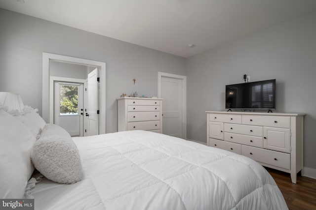 bedroom with access to outside and dark hardwood / wood-style floors