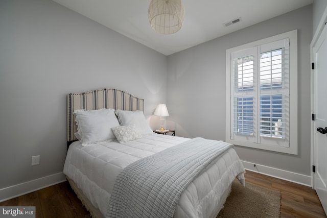 bedroom with dark hardwood / wood-style flooring