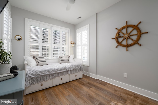 bedroom with multiple windows, ceiling fan, and hardwood / wood-style floors