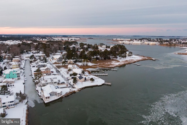 aerial view at dusk featuring a water view